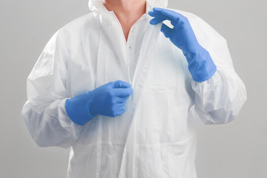 Close up shot the men in protective hazmat suit pull the zipper out after finish work at the hospital. macro shot men's hands unzips the PPE hazmat suit