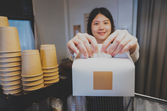 Image Of A Barista Serving A Snack Box To Customer In A Cozy Cafe