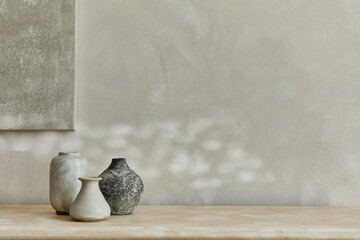 Stylish minimalistic monochromatic composition with design vases and personal accessories. Poster on the wall, copy space. Neutral colors. Template.