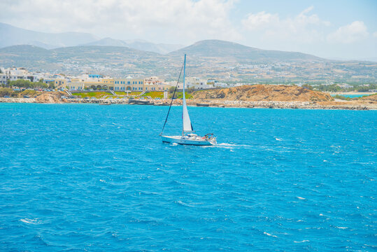 Greece famous Paros island in cyclades,view of paros island with a sail boat in foreground