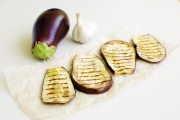 grilled eggplant with spices and garlic on a white background