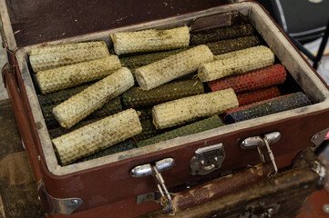 Lots of handmade wax candles in a vintage suitcase