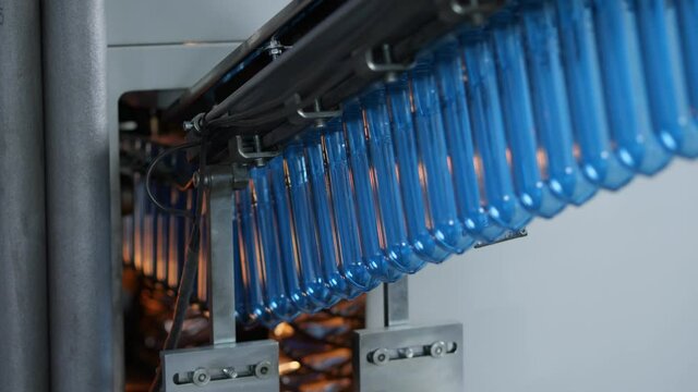 The blue preforms are sent to the blow molding machine. Production of plastic bottles at the mineral water bottling plant