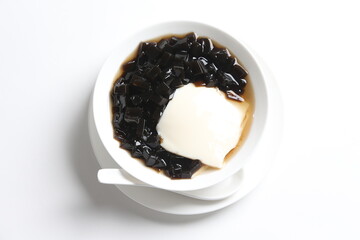 black herbal jelly with white soya milk pudding and sweet syrup in white bowl yuan yang traditional dessert menu