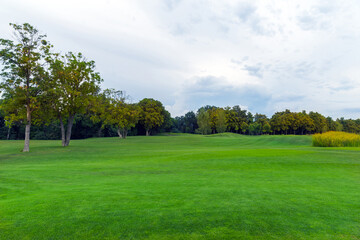 Fototapeta na wymiar Golf Course with soigne Green Grass in Summer Day