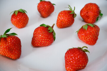 Fresh berries. Fresh juicy red strawberry on a white plate. Close-up photo. Vitamin charge.
