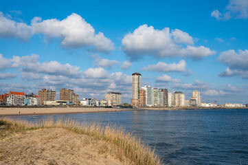 Waterfront, dunes and view on Vlissingen city with sandy beach on sunset