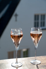 Drinking of rose champagne sparkling wine from flute glasses on outdoor terrace in France
