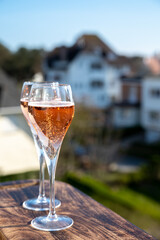 Drinking of rose champagne sparkling wine from flute glasses on outdoor terrace in France