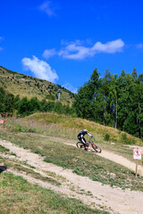 Fototapeta na wymiar Extreem outdoor sport challenge in French Alps mountains in summer, riding downhill on sport bike on special bicycle path