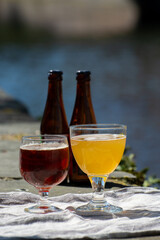 Tasting of Belgian beer on open cafe or bistro terrace with view on medieval houses and canals in Bruges, Belgium