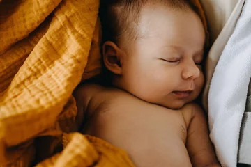 Fototapeten Closeup of a newborn baby dreaming and smiling while sleeping. © Bostan Natalia