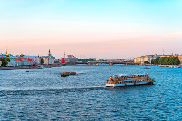 Obraz premium Summer panorama of the city and the river in St. Petersburg. Postcard view and the concept of river tourism at sunset