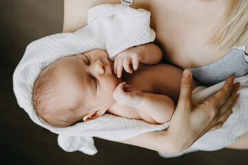 Newborn baby sleeping in mother's arms.