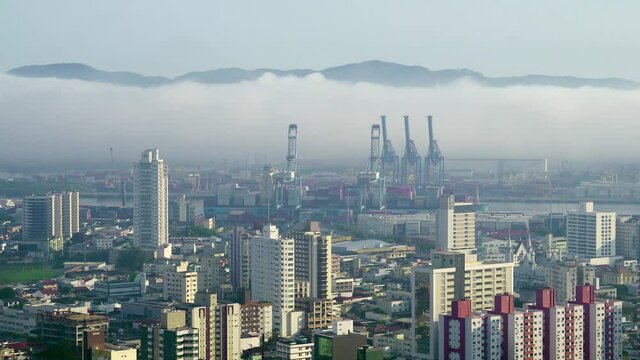 Container Port in Itajai, Santa Catarina in Brazil. Overall of the city showing the Container port with a cargo ship. Lower Clouds in the Background.