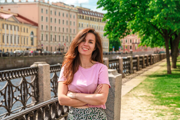 Beautiful young woman on the embankment in the center of St. Petersburg