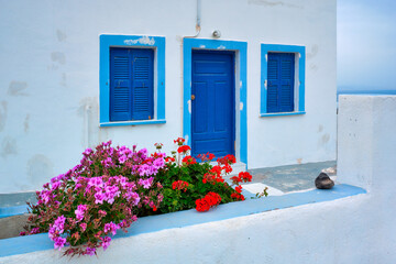 Greek white house with blue door and window blinds Oia village on Santorini island in Greece
