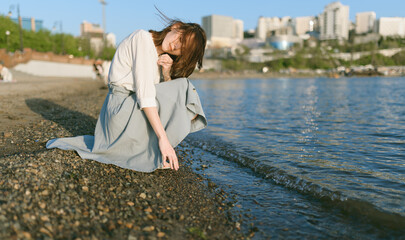 Woman in dress enjoys the sea shore.