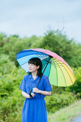 雨の中、カラフルな傘を指す女性