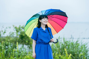 雨の中、カラフルな傘を指す女性