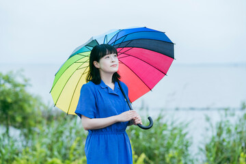 雨の中、カラフルな傘を指す女性