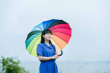 雨の中、カラフルな傘を指す女性