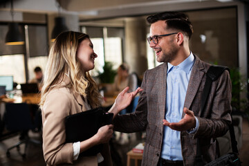 Colleagues talking in the office. Businesswoman and businessman discussing work in office.