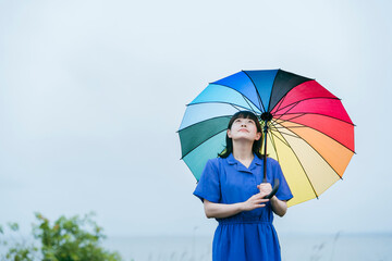 雨の中、カラフルな傘を指す女性