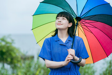 雨の中、カラフルな傘を指す女性