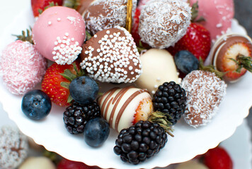 Variety of chocolate strawberries group of strawberries in chocolate on white plate and gray background, a dessert for Valentine's Day, a romantic, food gift.