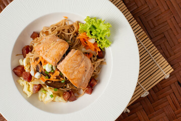 Spaghetti saimon with sausage on the wooden background.
