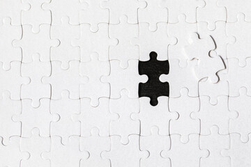 White jigsaw puzzle. White puzzle pieces on color background. Unfinished white jigsaw puzzle pieces...