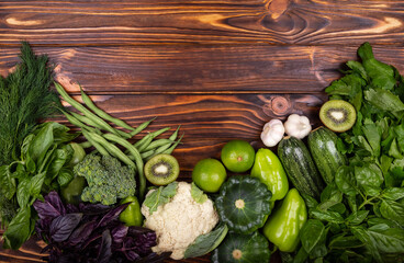 Healthy diet food. Organic produce. Green vegetable frame. Top view of healthy food clean food: frame of vegetables, superfoods, leafy vegetables on wooden background. Fresh vegetables background.