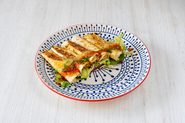 Fantastic plate of Mexican golden tacos ready to give you a good bite on light wooden table