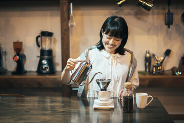 落ち着いた空間で、コーヒーを淹れる若い女性
