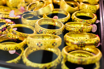 selective focus to gold and bracelet are gold jewelry in the showcase, the gold shop at Yaowarat, Bangkok, Thailand.