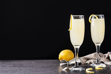 French 75 cocktail in glass on black background. Copy space