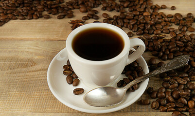 Cup of morning coffee on a wooden background, hot and fresh morning coffee. Fresh coffee. Roasted coffee beans. Copyspace