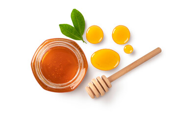 Honey in glass jar with dipper and leaves isolated on white background.