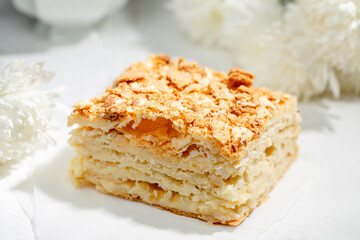 Cake Napoleon of puff pastry on white table