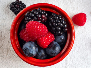 Variety of berries in a wooden cup, top view . 