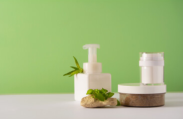 A set of cosmetics products with natural materials on a green background. Stones and wild plant. Natural organic cosmetic. Beauty concept.