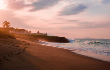 house villa on yje cost brutal waves romantically crash on terracotta rocks at sunset on a Caribbean island on the coast of the Atlantic Ocean