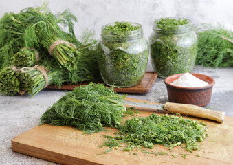 The process of preparing fresh green dill with salt for storage for the winter.