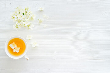 Tea in a cup with jasmine flowers. Herbal tea top view