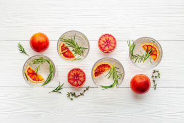 Glasses of cold drink with red oranges and rosemary