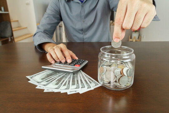 Investment and Saving money concept. businessman is putting conis in glass