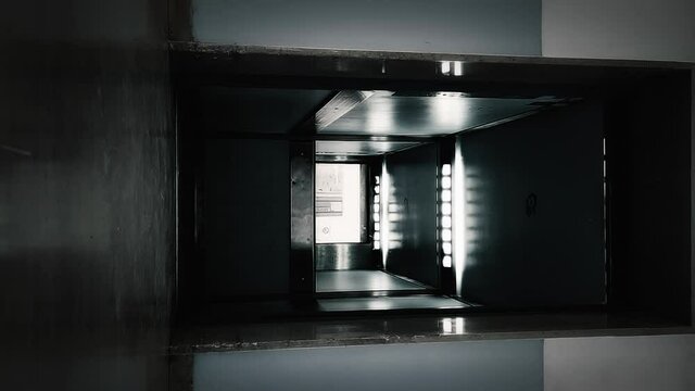 Vertical content: a scary lift (elevator), doors opening at one floor, showing nobody inside (it's empty). Horror halloween movie concept.