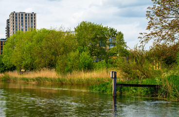 Riverside with apartment building and water level meter
