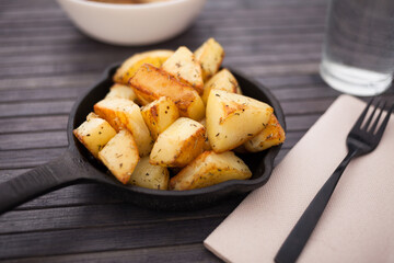 slices of fried potatoes on cast iron snack pan